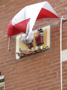 833434 Afbeelding van de herplaatste gevelsteen 'de huidenkopers' onder de opwapperende Utrechtse vlag, in het ...